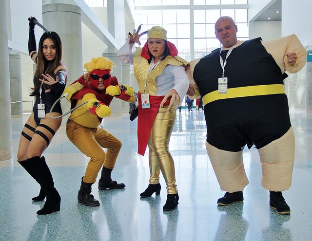Four cosplayers dressed as the Marvel characters Lady Deathstrike, Pyro, Psylocke and the Blob striking poses inside the Los Angeles Convention Center