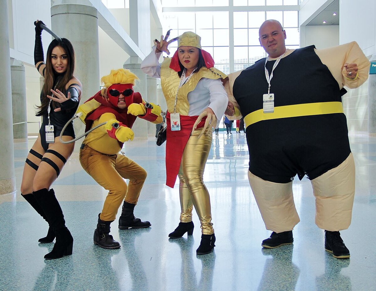 Four cosplayers dressed as the Marvel characters Lady Deathstrike, Pyro, Psylocke and the Blob striking poses inside the Los Angeles Convention Center