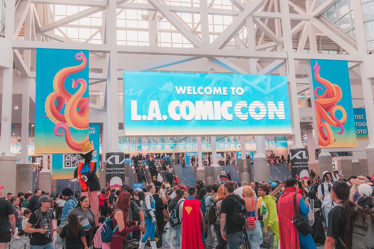 Cosplayers and fans crowd the lobby beneath a Welcome to L.A. Comic Con banner at the Los Angeles Convention Center