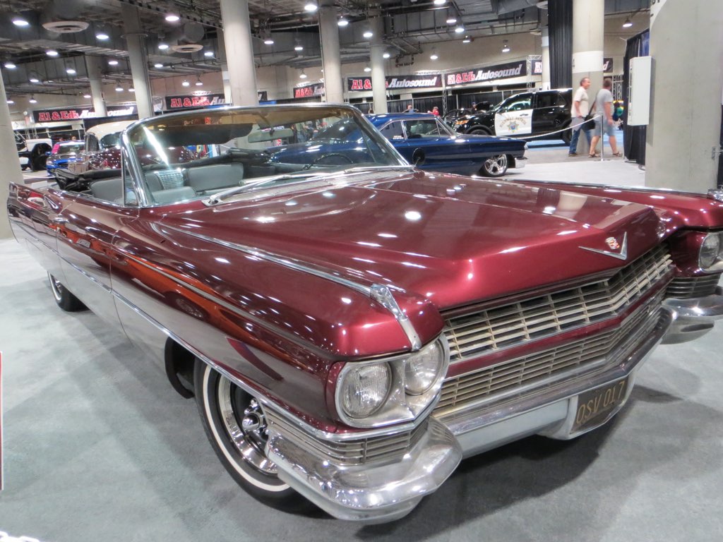 Rows of gleaming new cars on display inside a large convention center hall at the Los Angeles Auto Show
