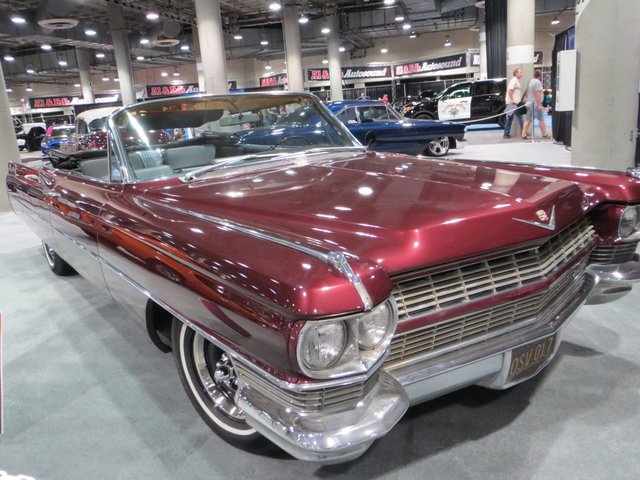 Rows of gleaming new cars on display inside a large convention center hall at the Los Angeles Auto Show