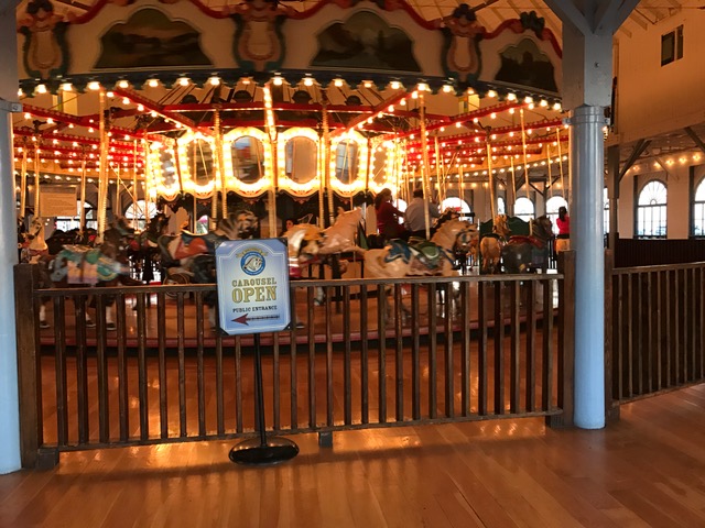The vintage carousel inside the Santa Monica Pier Carousel Building, with ornate horses and warm lighting
