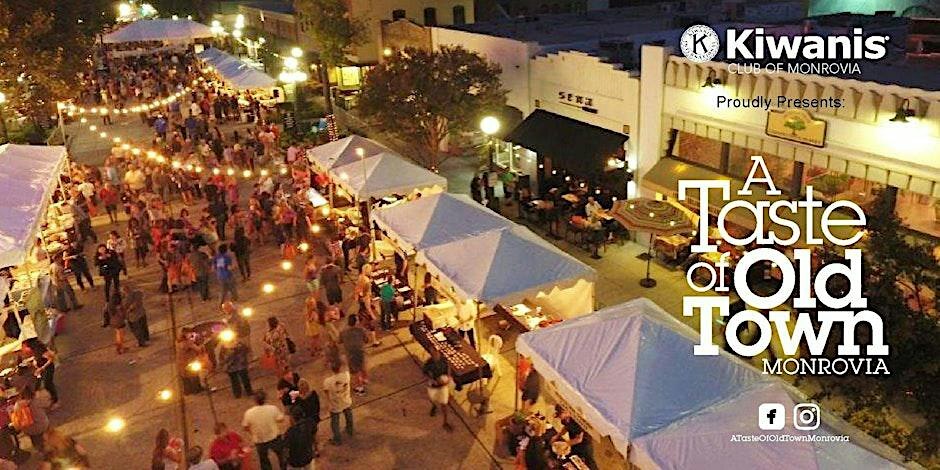 Aerial view of Myrtle Avenue at dusk lined with white vendor tents, string lights and crowds at A Taste of Old Town Monrovia