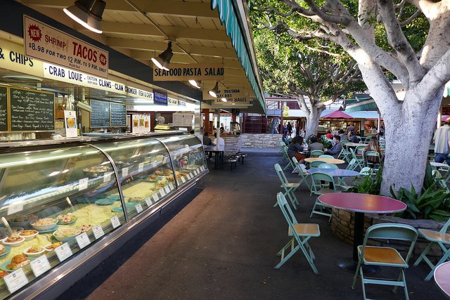 Shoppers browsing stands of fresh fruit and vegetables at an outdoor farmers market in Los Angeles