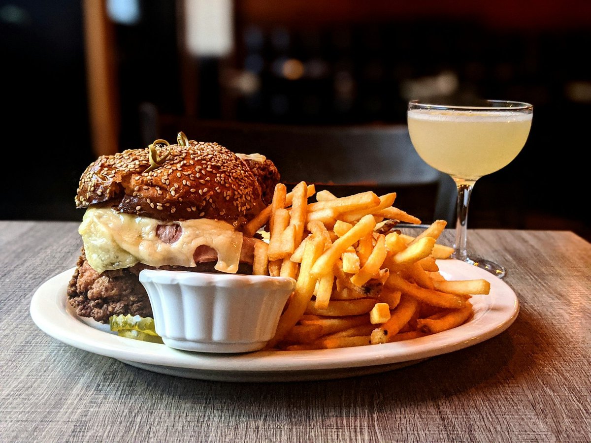 Six-ounce burger and a heap of fries on a white plate