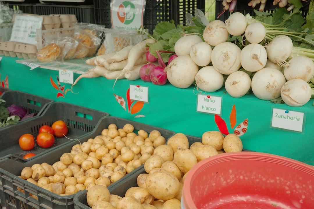 Fresh root vegetables and produce displayed at an outdoor farmers market stand
