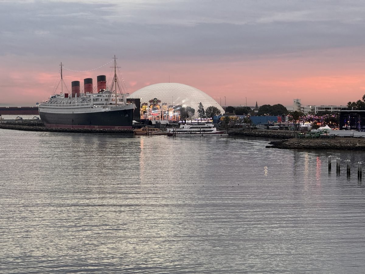 The Queen Mary ocean liner docked in Long Beach harbor at sunset