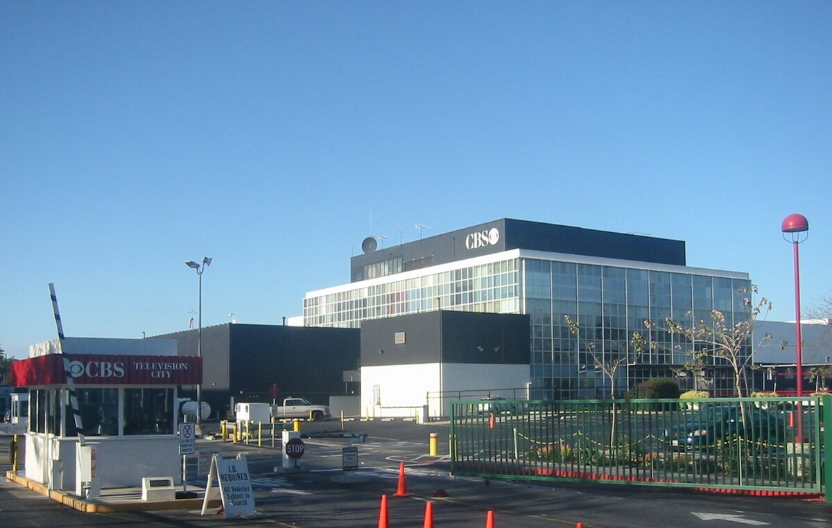 Entrance gate and studio building at CBS Television City on Beverly Boulevard under a clear blue sky
