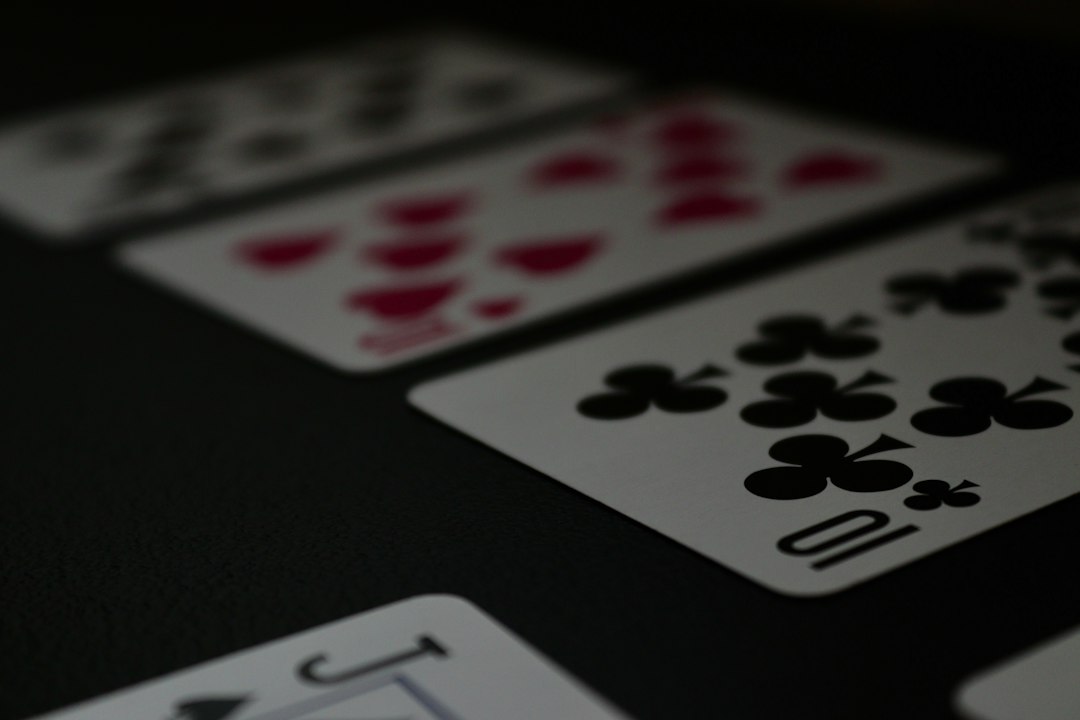 Close-up of playing cards laid out on a dark table, including the jack of spades