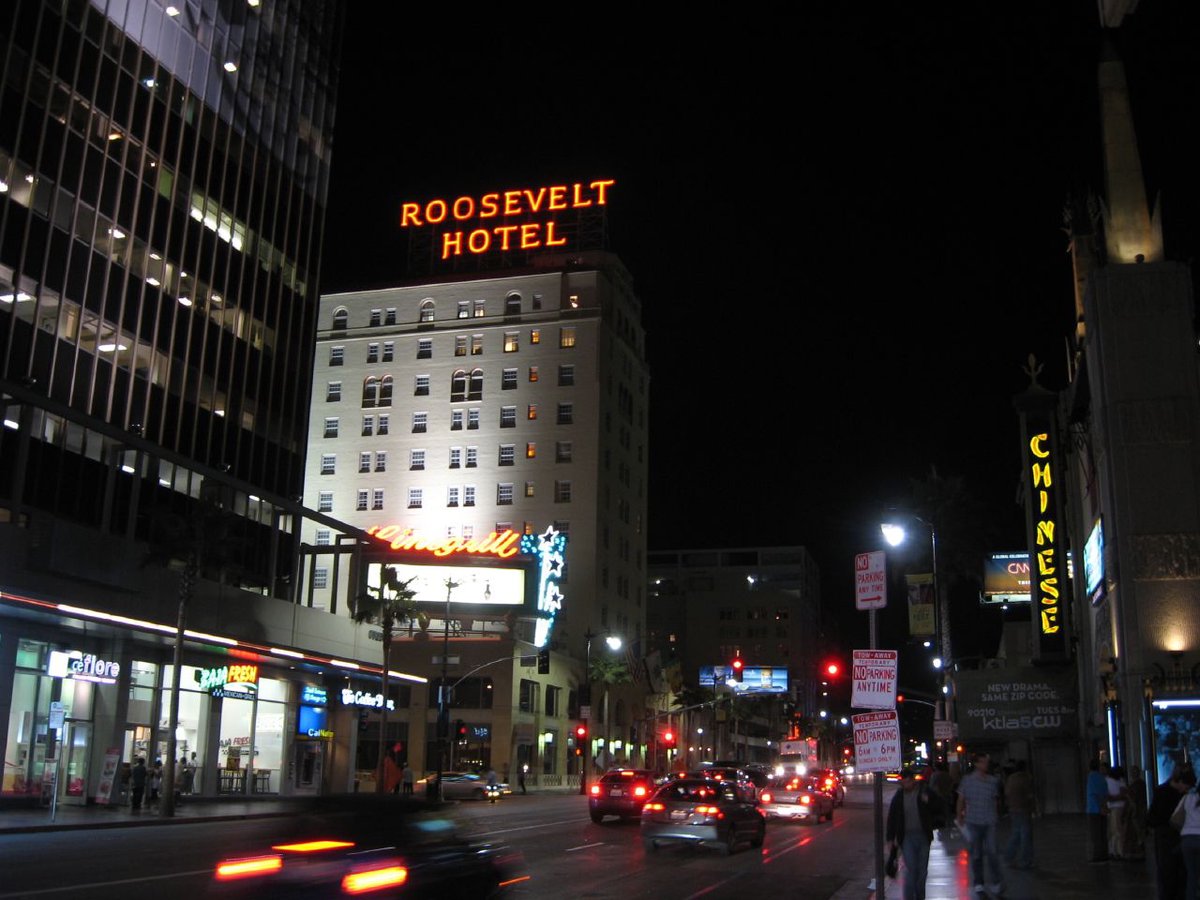 Hollywood Blvd at night with the neon Roosevelt Hotel sign and traffic heading past the Chinese Theatre, a few blocks west of Academy LA