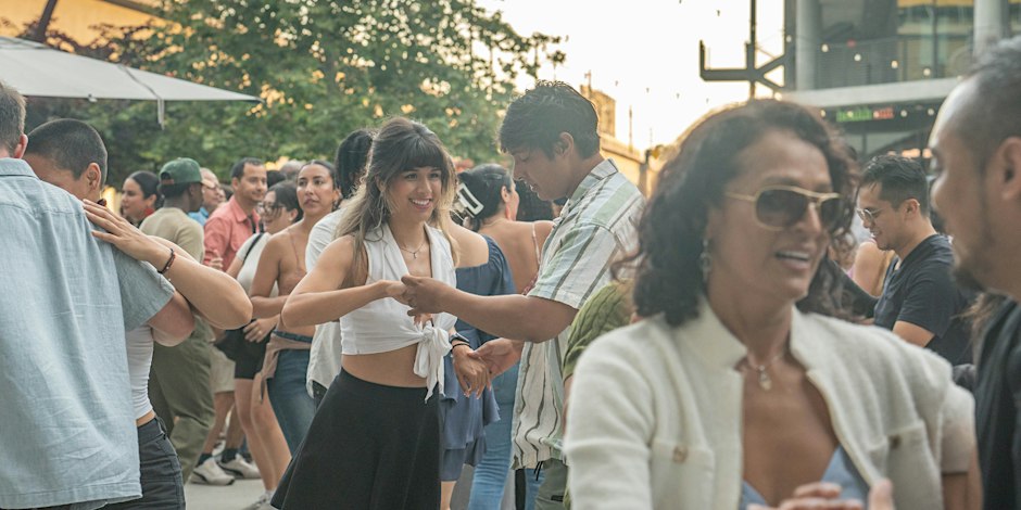 Dancers at an outdoor salsa night under string lights on a plaza