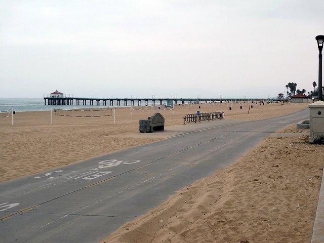 Manhattan Beach pier and boardwalk with the sand and coastline stretching into the distance