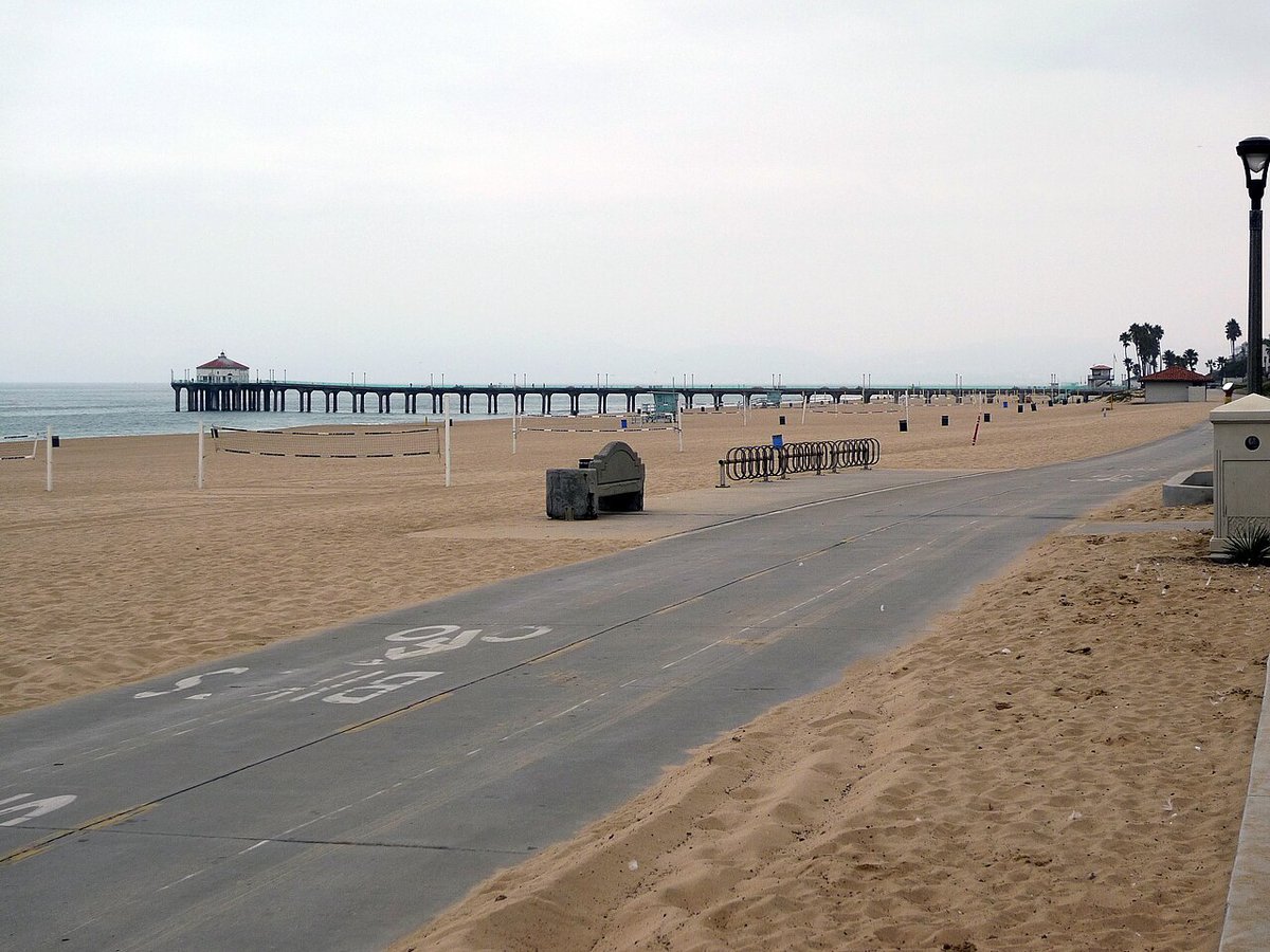 Manhattan Beach pier and boardwalk with the sand and coastline stretching into the distance