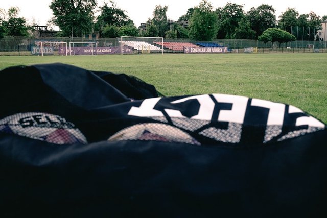 Soccer balls lined up on a green grass pitch ready for training or a match