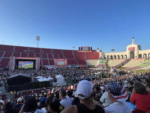 Fans filling the LA Memorial Coliseum during the 2026 FIFA World Cup Fan Festival, with the field and peristyle visible