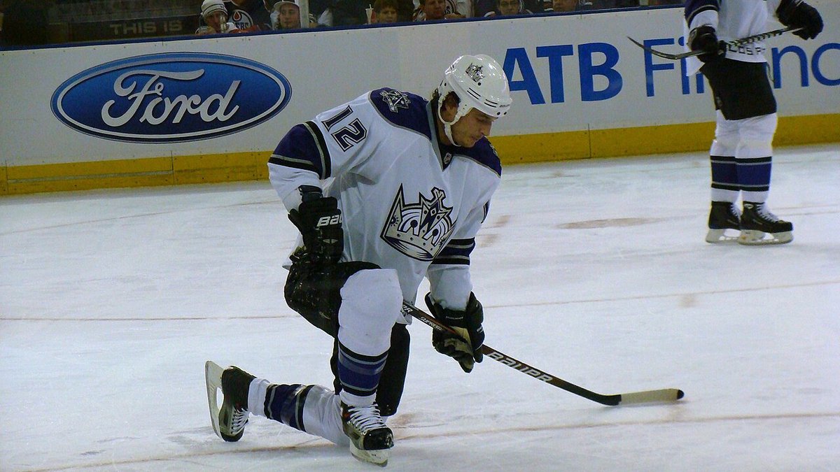 LA Kings hockey players on the ice during an NHL game, wearing black and white uniforms