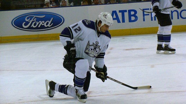 LA Kings hockey players on the ice during an NHL game, wearing black and white uniforms