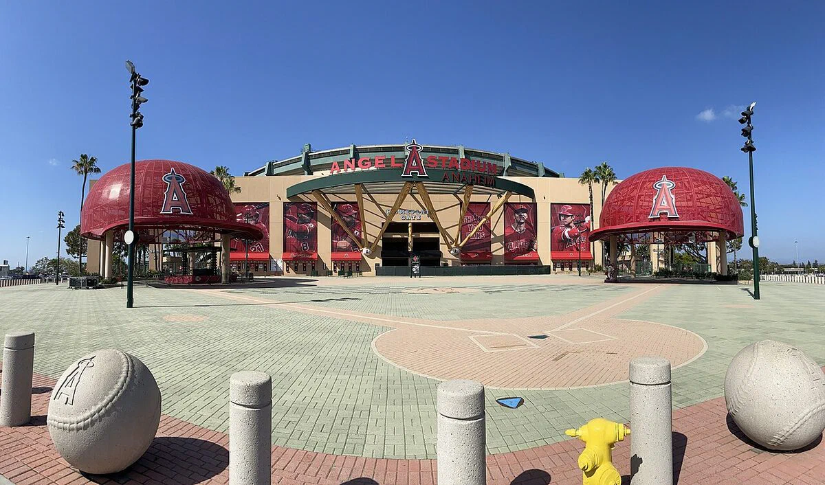 Angel Stadium's Home Plate entrance with two giant red Angels baseball caps and the Angel Stadium sign over the gate, on a sunny day