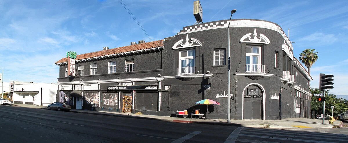 The black two-story Catch One building on West Pico Boulevard, with the Jewel's Catch One neon sign and the Jewel's Room door on the corner