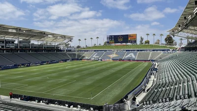The empty soccer stadium at Dignity Health Sports Park, with green field, grey seating and the canopy roof over the main stand