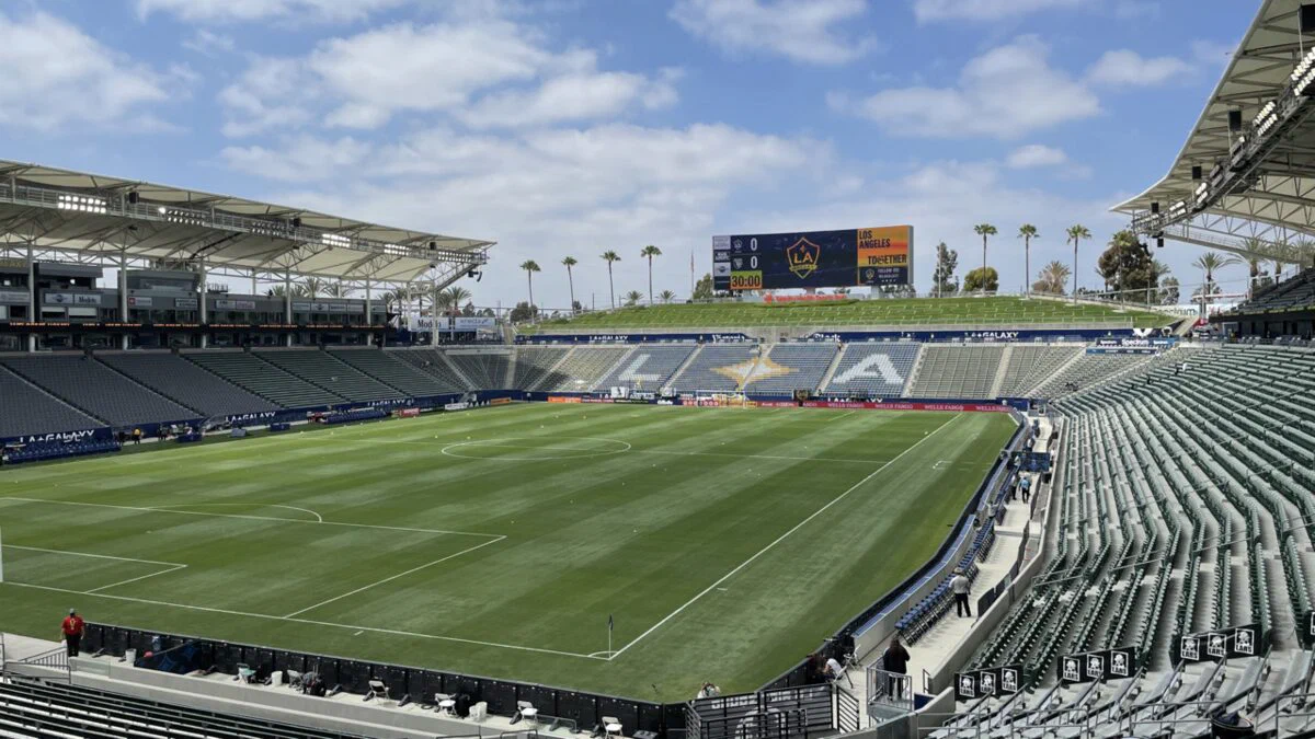 The empty soccer stadium at Dignity Health Sports Park, with green field, grey seating and the canopy roof over the main stand