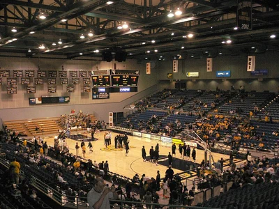 The Bren Events Center's basketball court and two-level seating bowl under the lights before a UC Irvine game