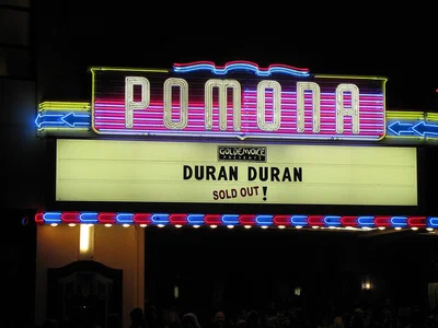 The neon POMONA sign and lit marquee of the Fox Theater Pomona at night, announcing a sold-out show