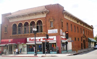 The red brick Highland Park Masonic Temple, home of Lodge Room, with arched upper windows and a tiled roof at the corner of Figueroa Street and Avenue 56