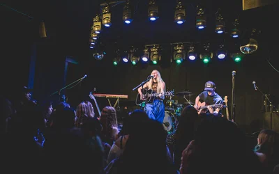 The Moroccan Lounge's small stage under rows of blue and green lights, seen over the crowd