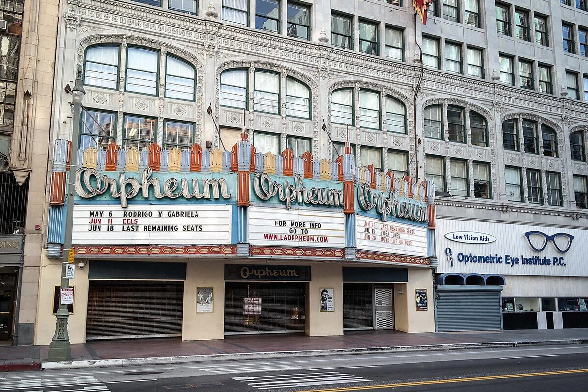 The Orpheum Theatre's three-part marquee under the ornate white facade of its building on Broadway in downtown Los Angeles