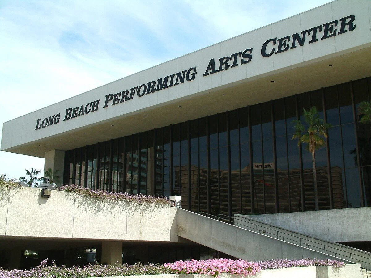 The glass front of the building that holds the Terrace Theater, with the Long Beach Performing Arts Center sign along its roofline, in Long Beach