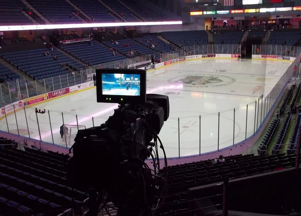 The bowl of seats around an empty hockey rink inside Toyota Arena in Ontario, seen past a TV camera, when the arena was still called Citizens Business Bank Arena