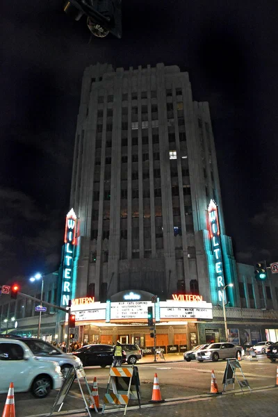 The Wiltern's tiled tower and lit marquee at night on the corner of Wilshire and Western in Los Angeles